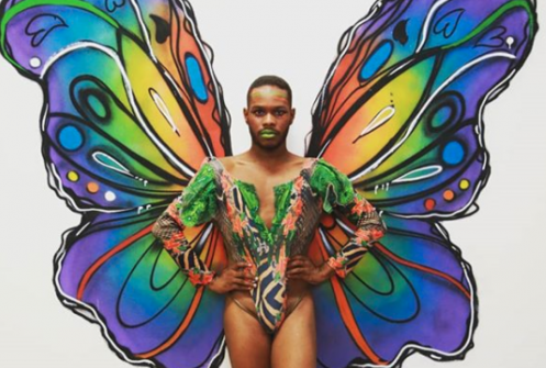 Man in brightly coloured body paint with butterfly wings
